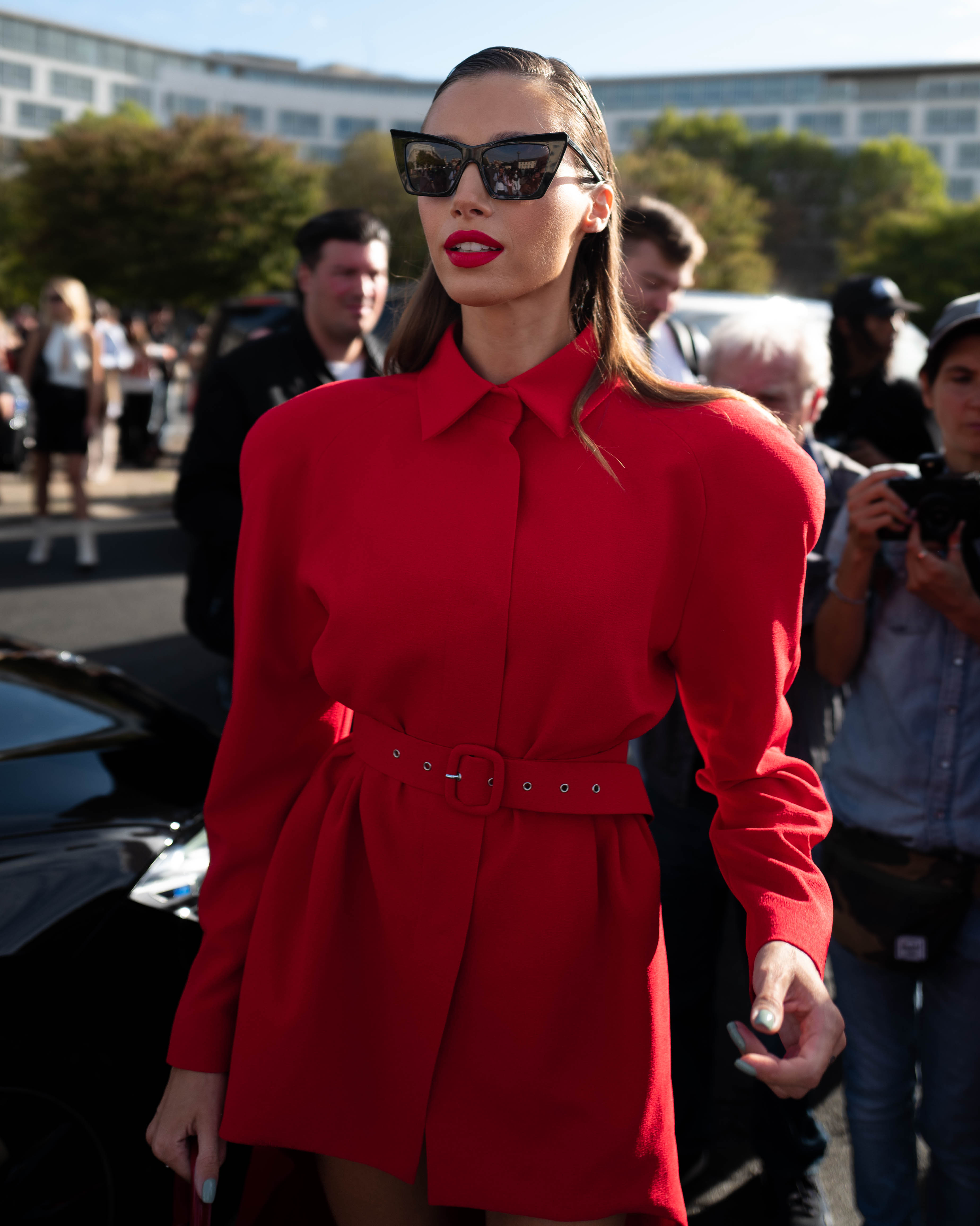 A guest wears a Givenchy dress with red Jacquemus bag and black sunglasses. Street Style At Givenchy SS24 Show Paris Fashion Week