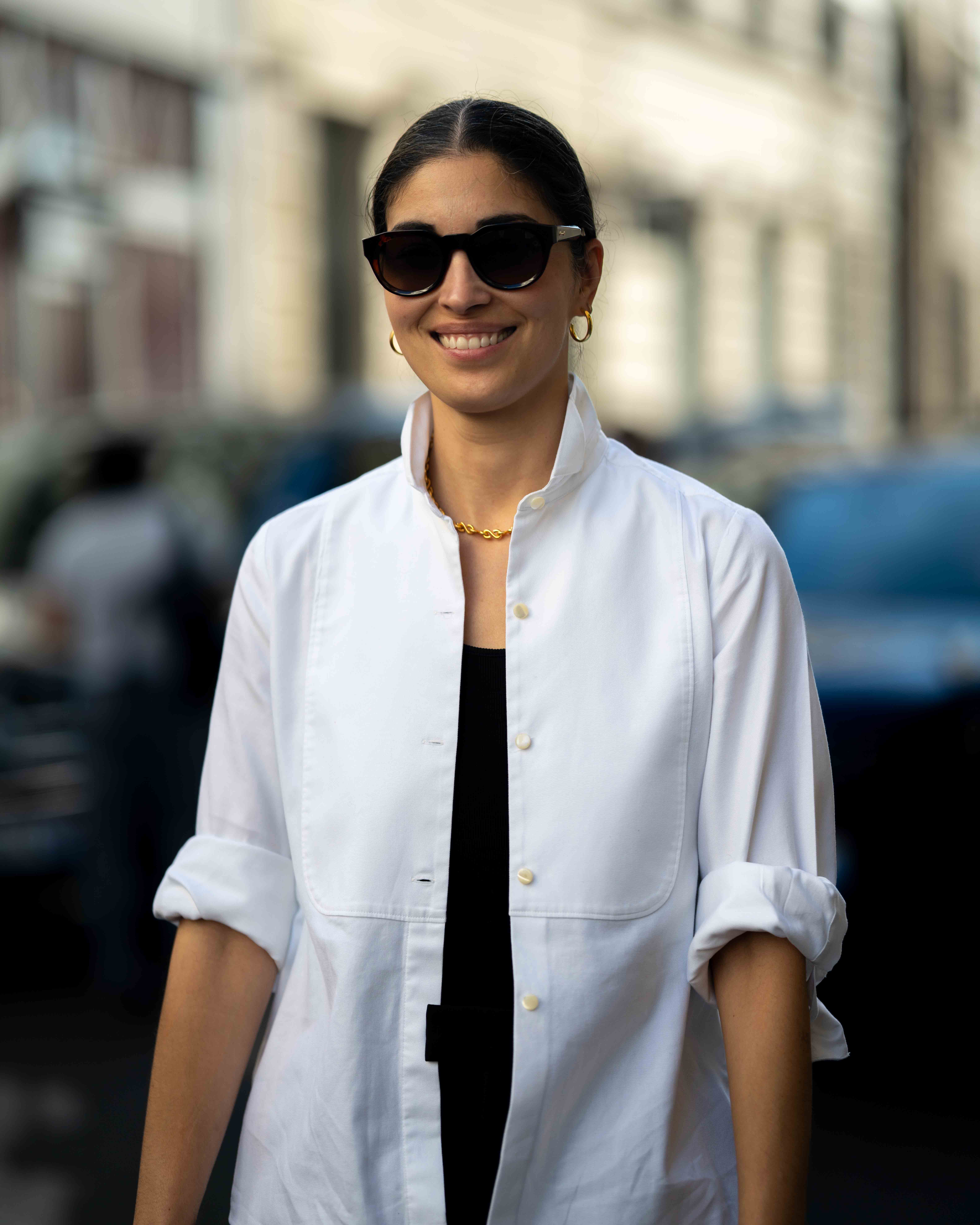 Caroline Issa wears a white dress shirt, open, with a black top underneath and dark sunglasses.
Street Style After Valentino SS24 Paris Fashion Week